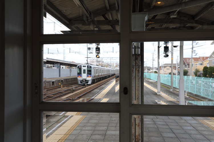南海本線浜寺公園駅ホーム上の待合室内部から列車を見る